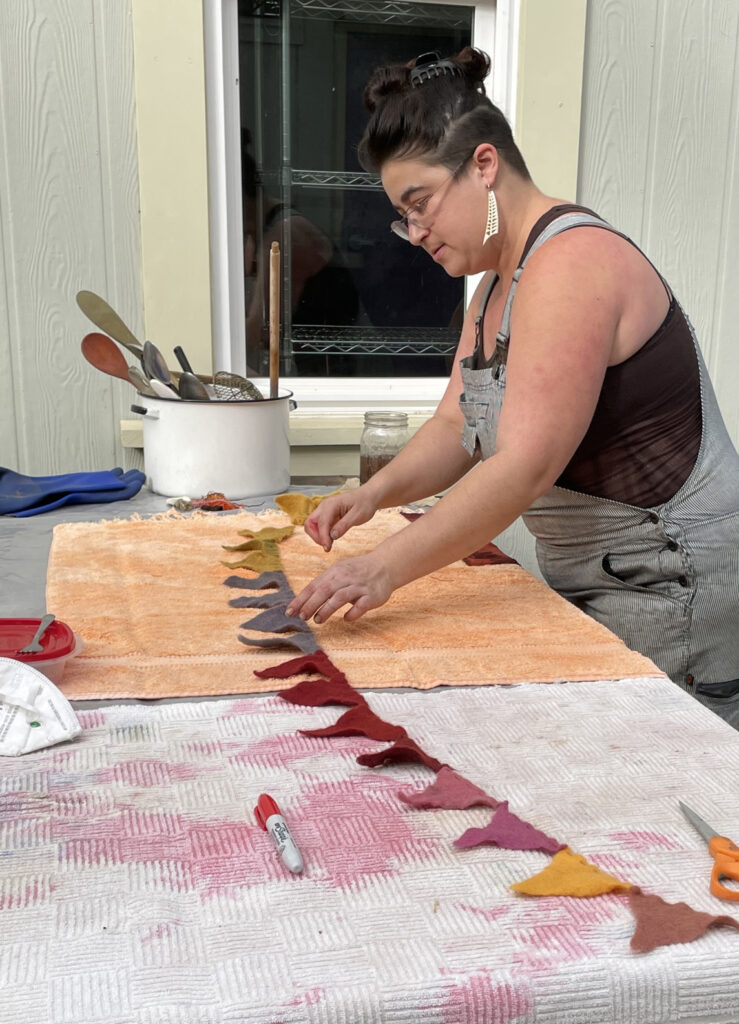 woman making dyed felt flag banner