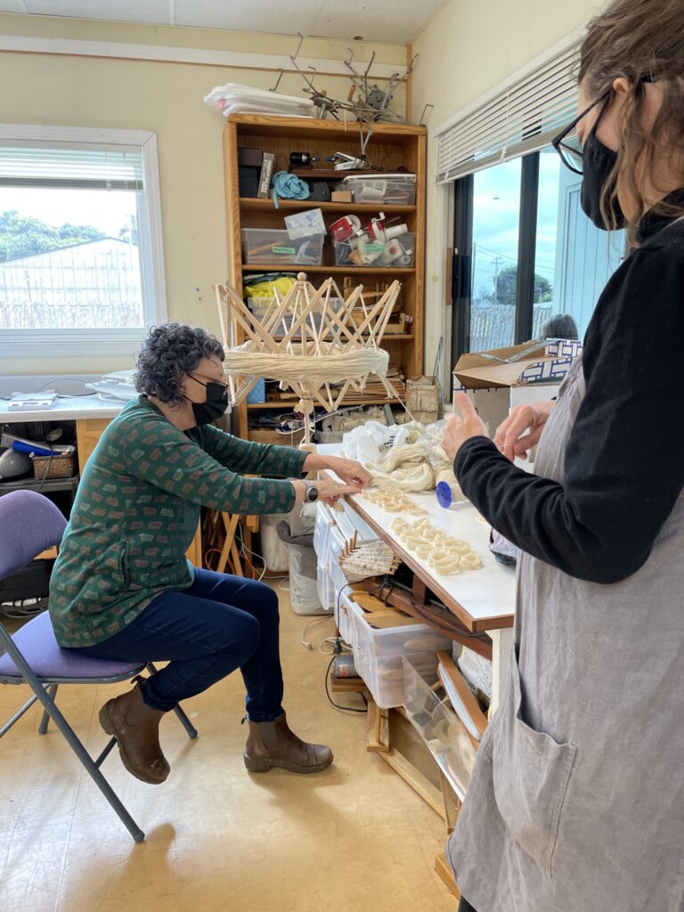 two women making yarn skeins for dyeing